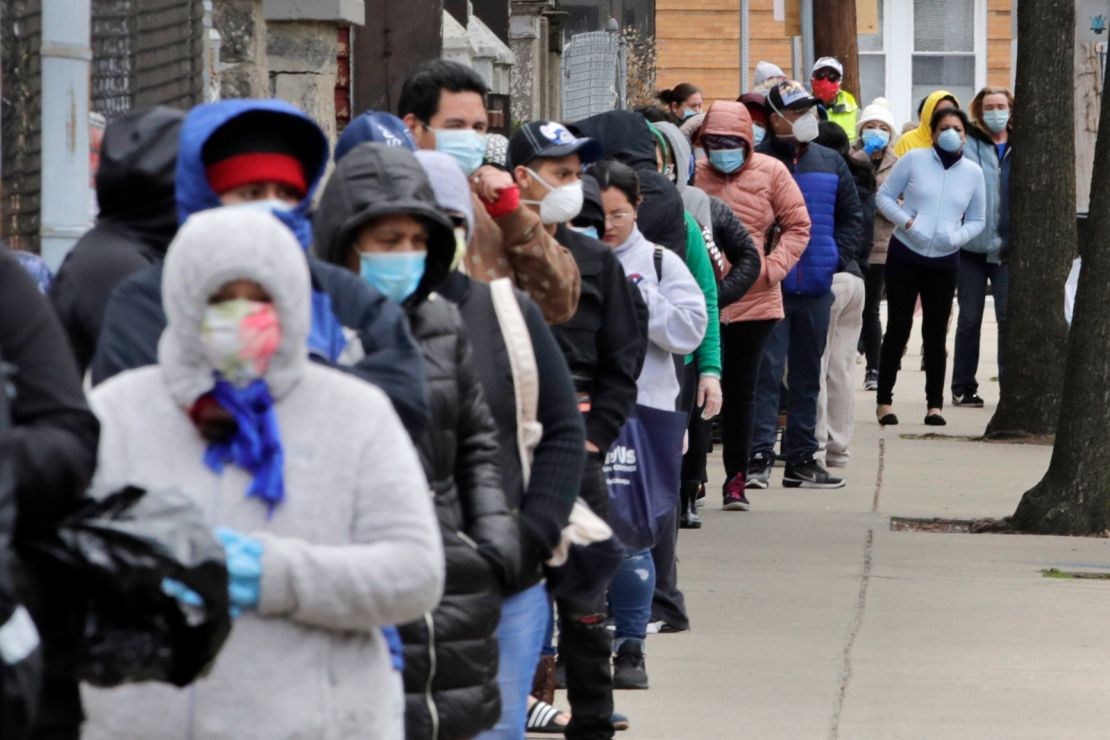 Hundreds impacted by the Covid-19 virus outbreak wait in line for boxes of food at a Salvation Army center in Chelsea, Mass.