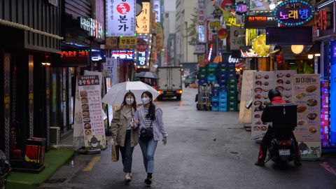 Two women wear face masks in Seoul. Countries in which covering one's face is a social norm have generally fared better during the pandemic.