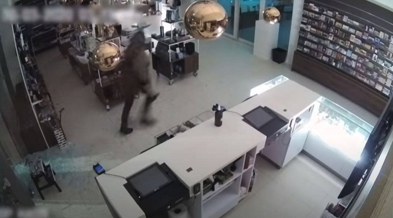 The burglar can be seen smashing two glass doors to enter the museum.