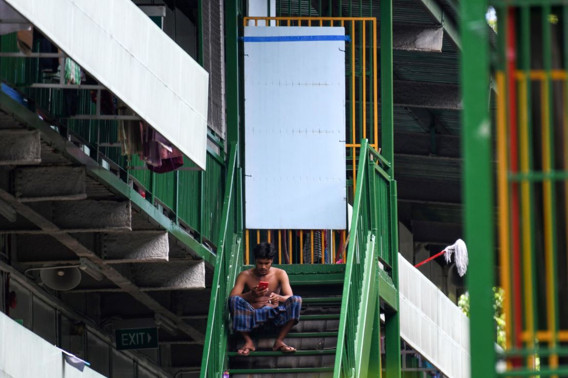 A migrant worker rests on a staircase at a dormitory in Singapore, on April 22.