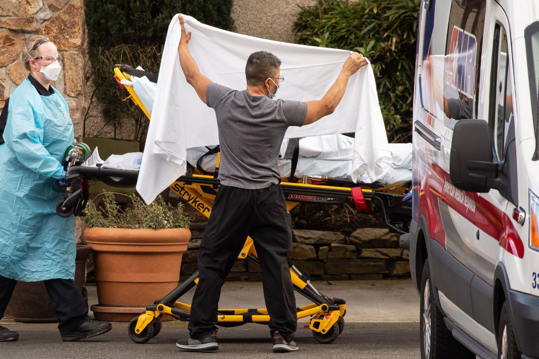 Healthcare workers transport a patient on a stretcher into an ambulance at Life Care Center of Kirkland in Washington state. (David Ryder/Getty Images)