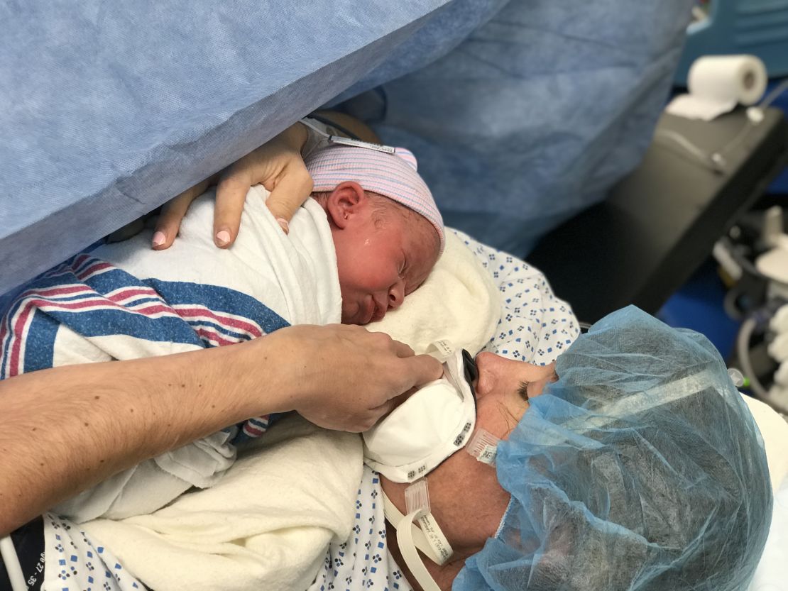 River Weir meets his mom, complete with mask, for the first time.