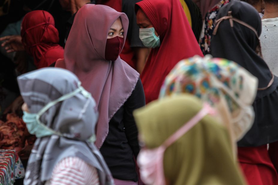 Marketgoers in Lhokseumawe, Indonesia, wear masks while preparing to buy meat for the Ramadan holiday on April 23.