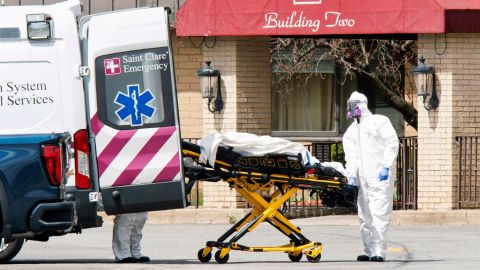 Medical workers load a deceased body into an ambulance while wearing masks and personal protective equipment (PPE) at Andover Subacute and Rehabilitation Center in Andover, New Jersey on April 16, 2020. 