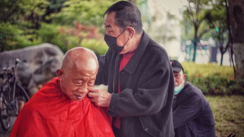 A man gets his haircut at an outdoor barber in a Wuhan park on April 23.