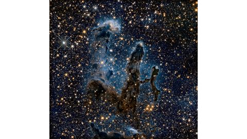 This is a near-infrared image of the Pillars of Creation, columns of gas and dust where new stars are born. It shows the new stars that weren't apparent in the visible light version of the image, which can be seen in the gallery.