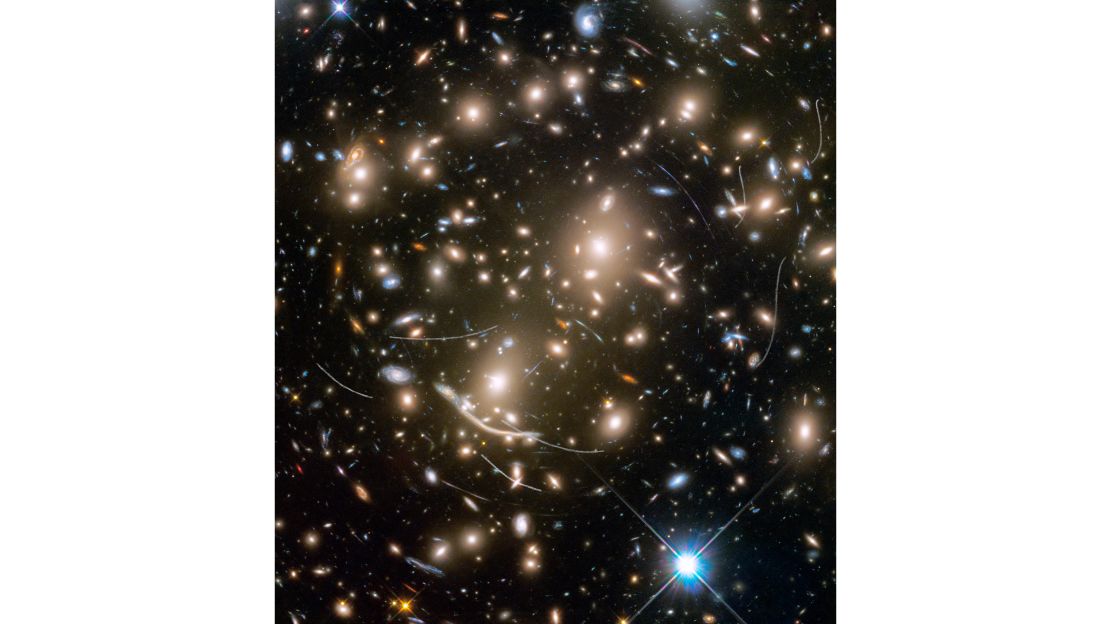 Hubble captured this image of the distant galaxy cluster Abell 370, where several hundred galaxies are pulled together by gravity. They're four billion light-years away, but the streaks in the image belong to asteroids 160 million miles from Earth.