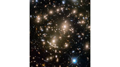 Hubble captured this image of the distant galaxy cluster Abell 370, where several hundred galaxies are pulled together by gravity. They're four billion light-years away, but the streaks in the image belong to asteroids 160 million miles from Earth. 