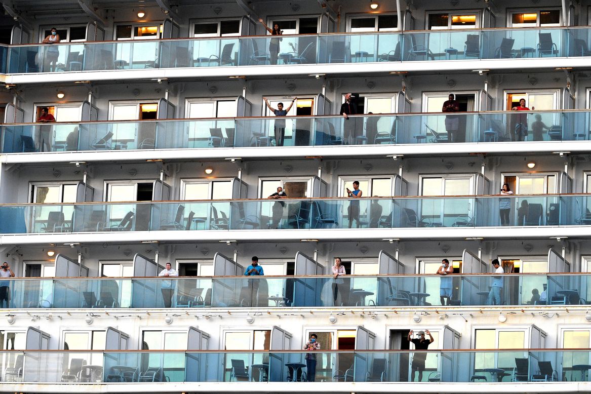 People wave as the cruise ship Ruby Princess departs from Port Kembla, Australia, on Thursday, April 23. Crew members are going back to their home countries.