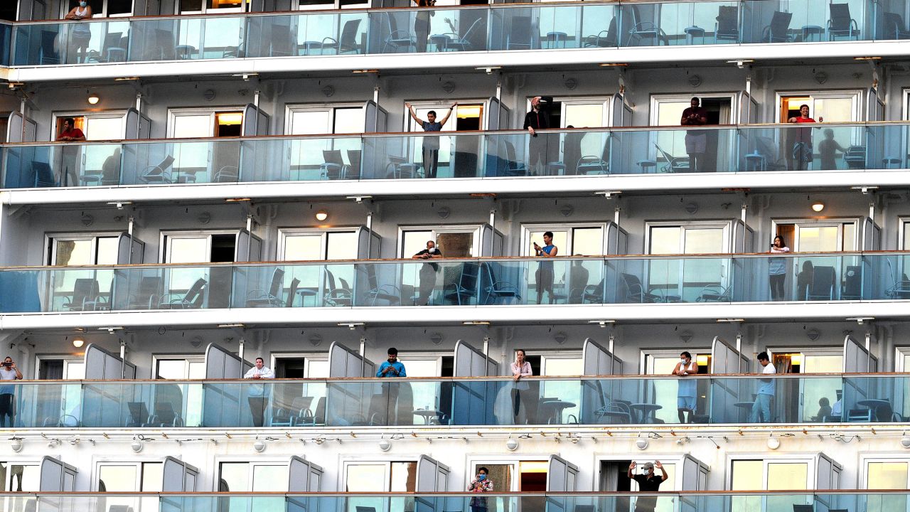 People wave as the cruise ship Ruby Princess departs from Port Kembla, some 80 kilometres south of Sydney, on April 23, after a few hundred virus-free crew members disembarked to begin the process of repatriation to their home countries.