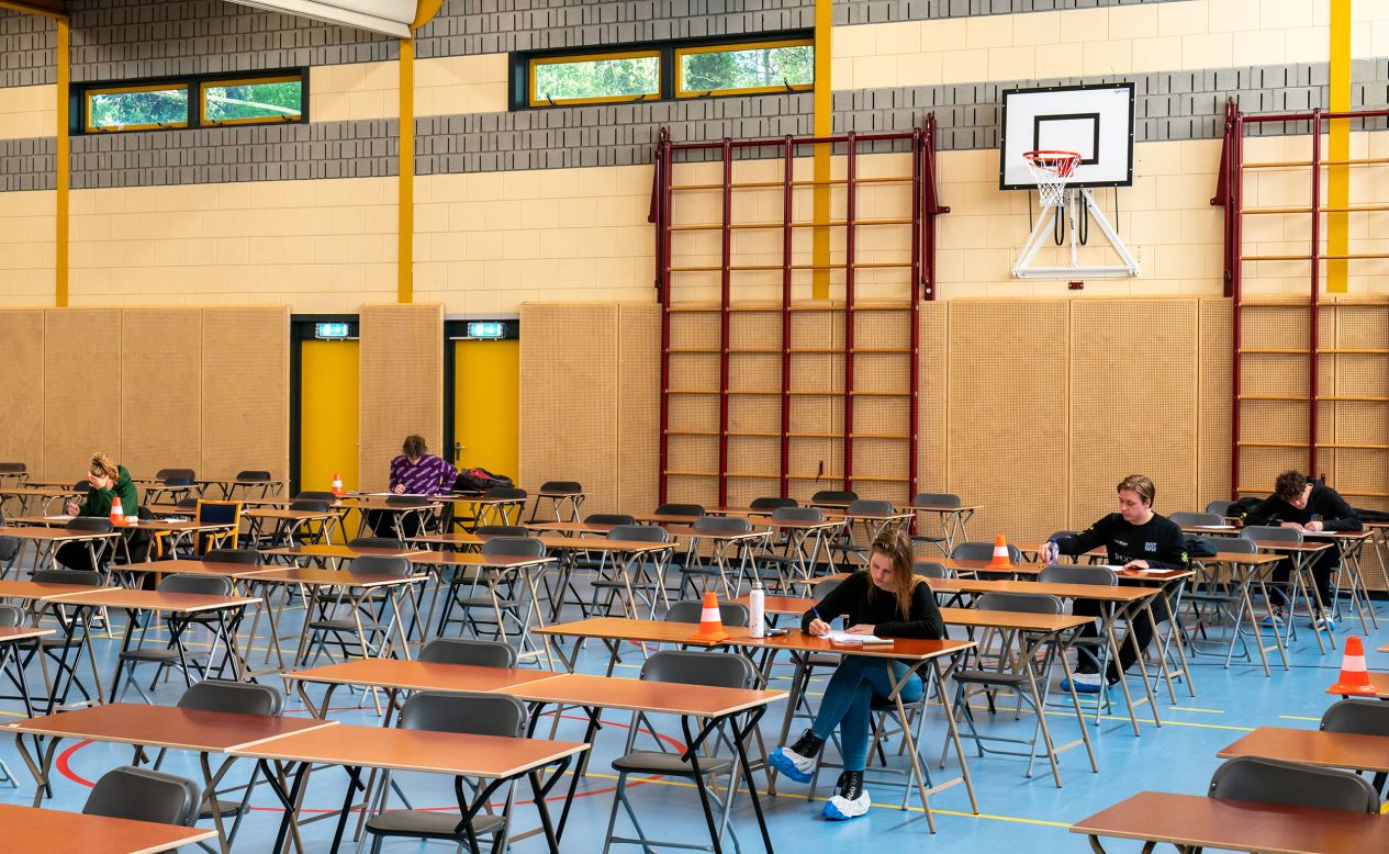 Students take exams at a high school in Overeen, Netherlands, on Tuesday, April 21. Students sat away from one another and wore protective slippers over their shoes. 