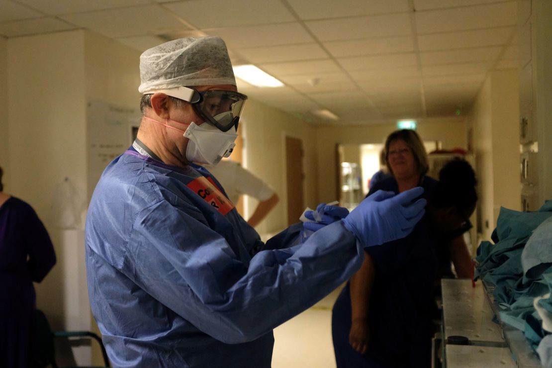 Dr. Roger Townsend dons PPE before entering the critical care unit.