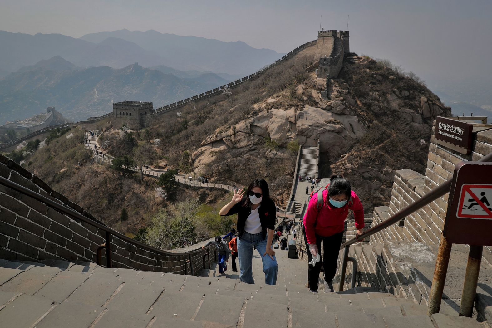 On April 14, people wearing protective face masks walk on a small stretch of the<a  target="_blank"> Great Wall of China</a> that had been reopened.