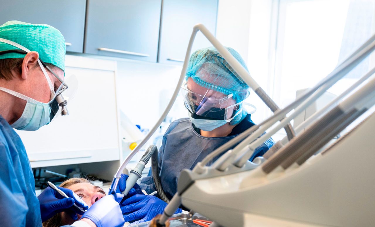 Dentist Torben Schoenwaldt and clinical assistant student Rebecka Erichsen care for a patient at Harald Dentists Soenderaaparken in Vejle, Denmark. The office reopened on April 20 and is accepting patients again.