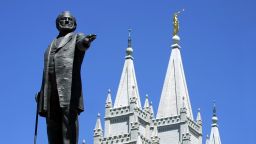 SALT LAKE CITY, UNITED STATES:  A statue of Brigham Young, second president of the Church of Jesus Christ of Latter Day Saints stands in the center of Salt Lake City with the Mormon Temple spires in the background 19 July 2001. Salt Lake City will be the host of the 2002 Winter Olympics. AFP Photo/George FREY (Photo credit should read GEORGE FREY/AFP via Getty Images)