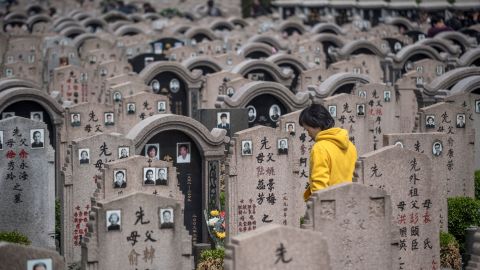 A woman decorates a grave during the Qing Ming festival, also known as Tomb Sweeping Day, at a cemetery in Shanghai on April 6, 2018. Traditional religious practice is growing in China, but the government tightly controls foreign faiths. 