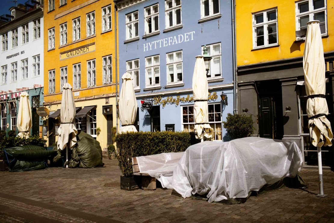 Tables are covered up outside shuttered restaurants in the popular tourist area of Nyhavn in Copenhagen, Denmark, on April 15.