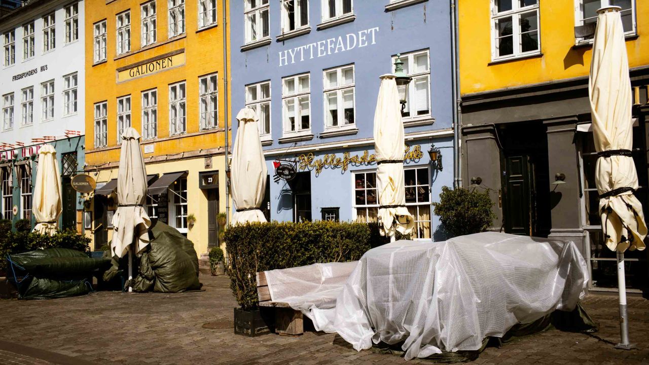 Tables are covered up outside shuttered restaurants in the popular tourist area of Nyhavn in Copenhagen, Denmark, on April 15.