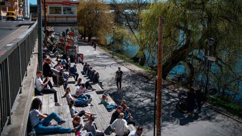 People enjoy the warm spring weather as they sit by the water at Hornstull in Stockholm on April 21.
