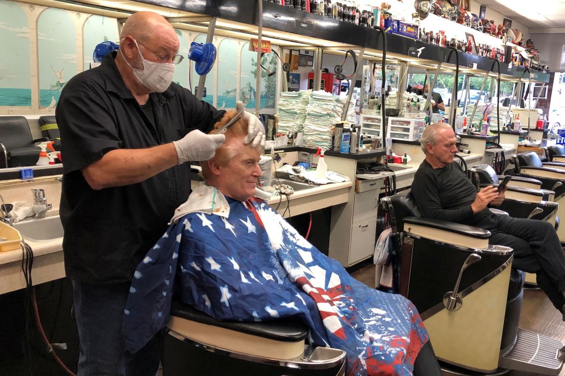 Barber Tommy Thomas gives his long-time customer Fred Bentley a haircut after the Georgia governor allowed a select number of businesses to open in Atlanta on Friday, April 24, 2020.