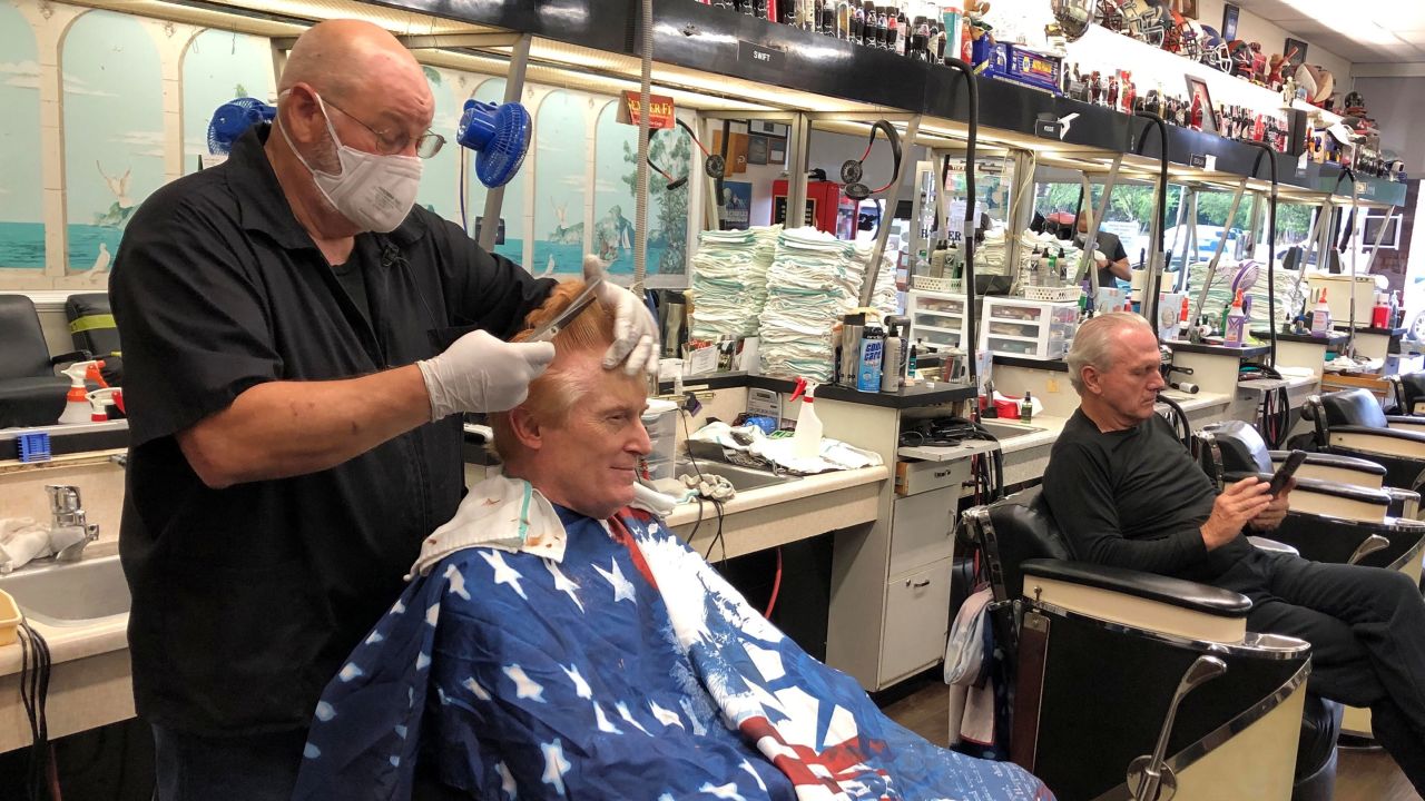 Barber Tommy Thomas gives his long-time customer Fred Bentley a haircut after the Georgia governor allowed a select number of businesses to open in Atlanta on Friday, April 24, 2020.