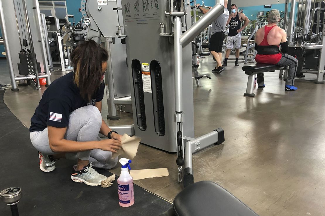 Sterling Henderson, 27, cleans gym equipment at Bodyplex Fitness Adventure on Friday, April 24 in Grayson, Georgia.