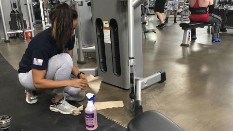 Sterling Henderson, 27, cleans gym equipment at Bodyplex Fitness Adventure on Friday, April 24 in Grayson, Georgia.