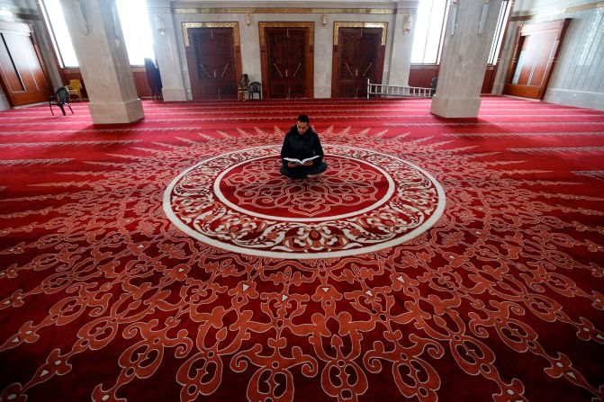 A muezzin, the person at a mosque who calls Muslims to daily prayers, reads the Quran at a mosque in Gaza City after <a href="index.php?page=&url=http%3A%2F%2Fwww.cnn.com%2F2020%2F04%2F23%2Fworld%2Fgallery%2Framadan-2020%2Findex.html" target="_blank">Ramadan began</a> on April 24, 2020.
