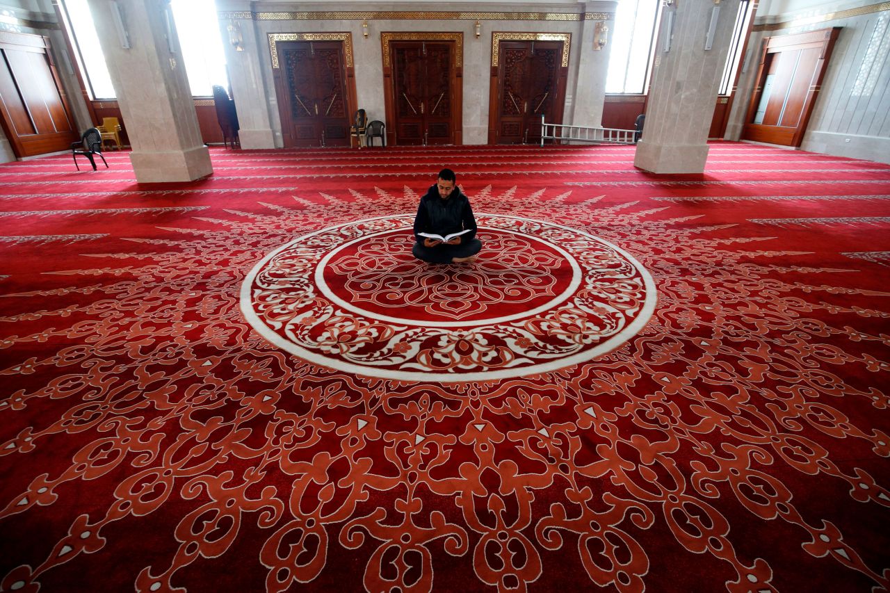 A muezzin, the person at a mosque who calls Muslims to daily prayers, reads the Quran at a mosque in Gaza City after <a href="http://www.cnn.com/2020/04/23/world/gallery/ramadan-2020/index.html" target="_blank">Ramadan began</a> on April 24, 2020.