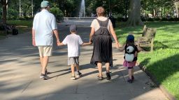 David P. Gelles' parents holding hands with their grandchildren on a walk in Philadelphia in July 2019.