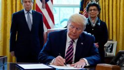 President Donald Trump signs a coronavirus aid package to direct funds to small businesses, hospitals, and testing, in the Oval Office of the White House, Friday, April 24, 2020, in Washington. Sen. Roy Blunt, R-Mo., left, and Jovita Carranza, administrator of the Small Business Administration look on.