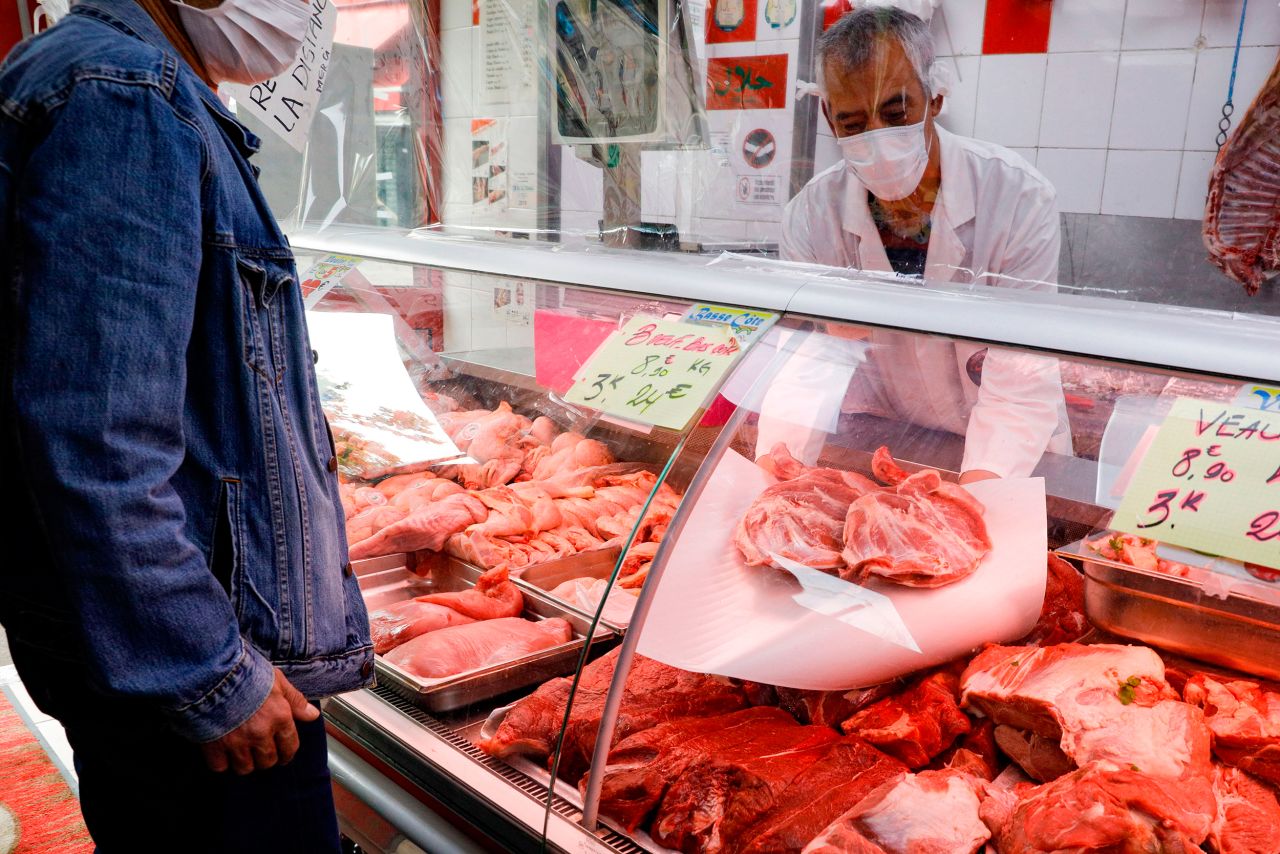 A butcher shows pieces of lamb to a client in Paris on April 24.