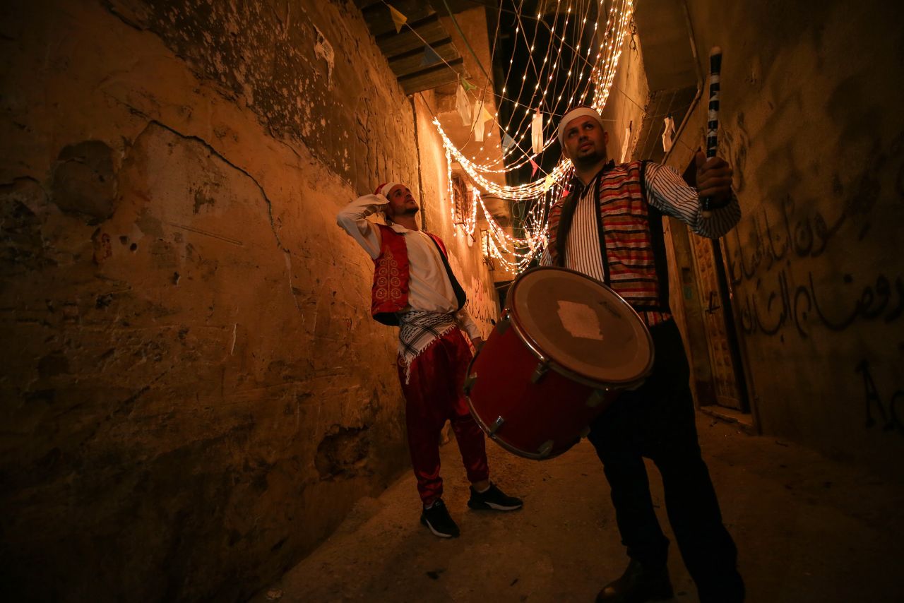 Drummers wearing traditional clothes play and read folk poetry to wake people for the sahur meal in Gaza City on April 24. Sahur is the last meal before a long day of fasting.