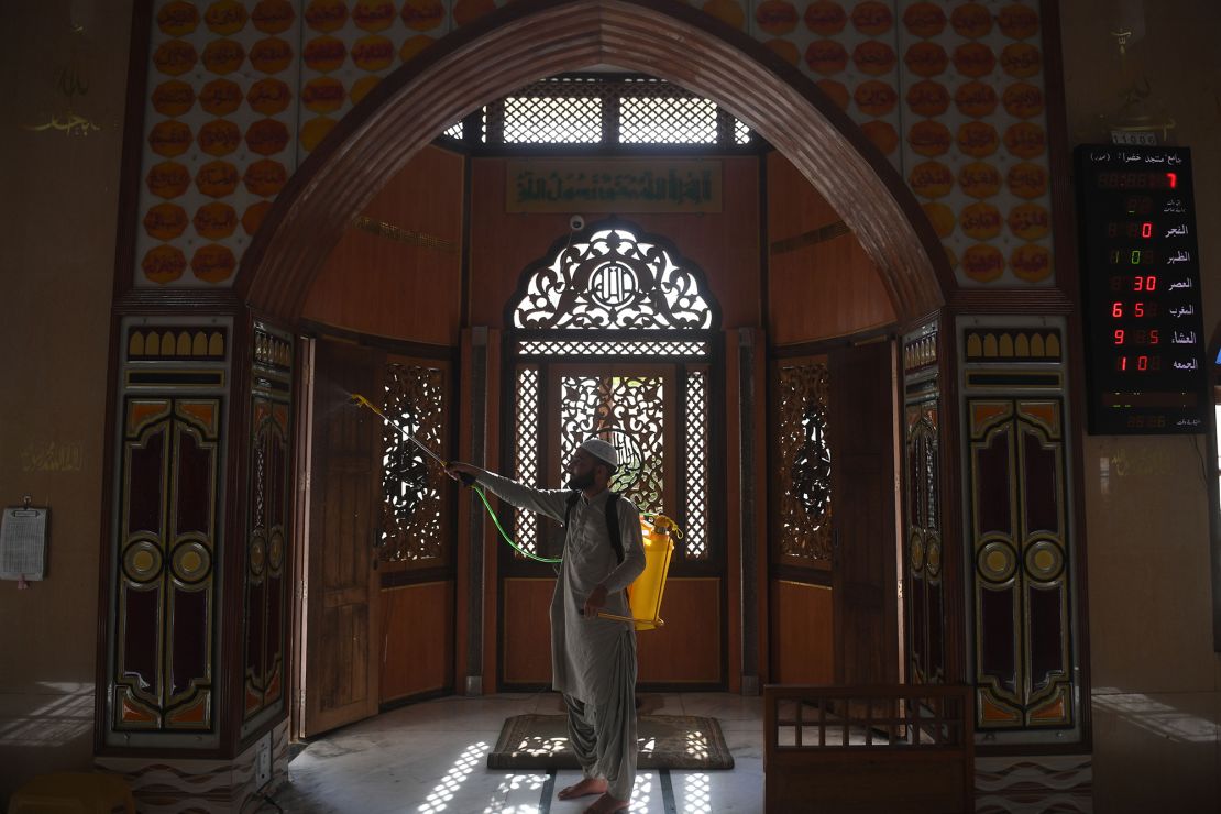 A Muslim devotee sprays disinfectant in a mosque ahead of the Muslim holy month of Ramadan during a government-imposed nationwide lockdown in Karachi on April 23, 2020. 