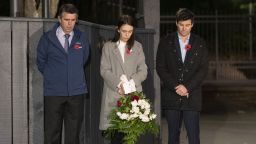 New Zealand Prime Minister Jacinda Ardern (C) with her father Ross Ardern (L) and partner Clarke Gayford stand in respect outside premier house in remembrance of ANZAC in Wellington on April 25, 2020. - The traditional ANZAC service has been cancelled due to the government declaring Alert Level 4 with dur to the novel coronavirus pandemic. (Photo by ROSS GIBLIN / POOL / AFP) (Photo by ROSS GIBLIN/POOL/AFP via Getty Images)