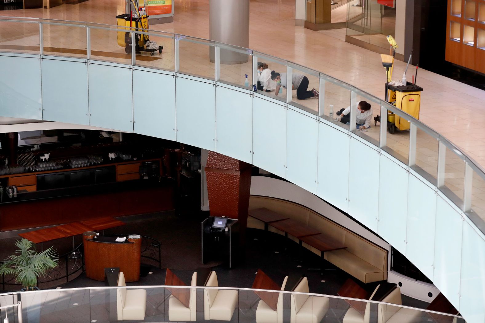 Employees wearing gloves and masks clean walls and railings at the Galleria Dallas mall on April 24. Texas began <a  target="_blank">a "retail-to-go" approach, </a>allowing retail stores to sell to customers through curbside and delivery.