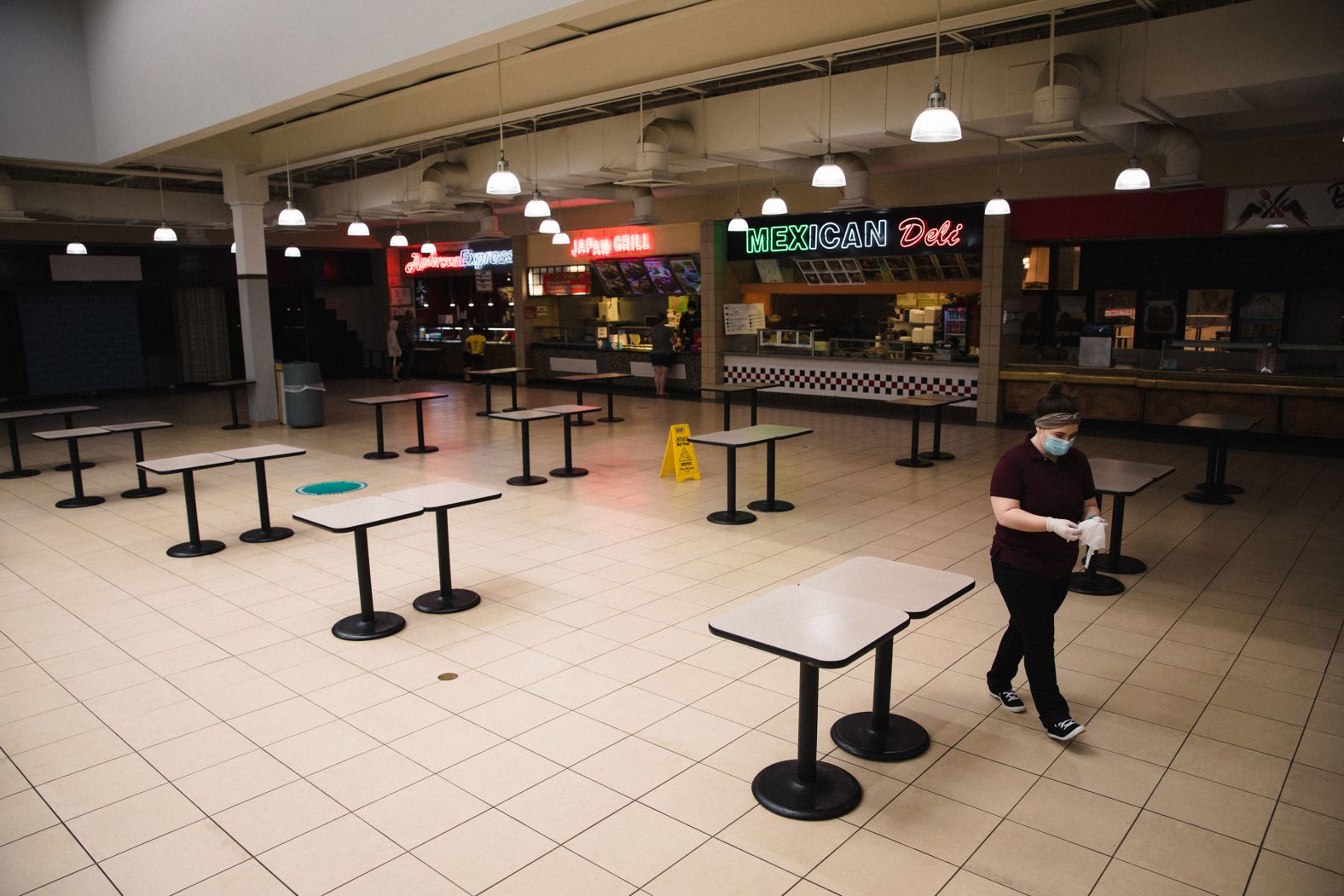 A person wearing a protective mask walks through the takeout-only food court at the reopened Anderson Mall in Anderson, South Carolina, on April 24.