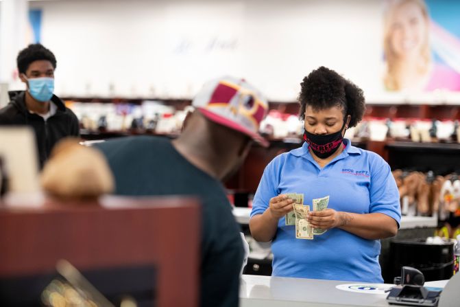 A cashier at the Shoe Dept. store rings up a customer at Columbia Place Mall in Columbia, South Carolina, on April 24. Gov. Henry McMaster <a href="index.php?page=&url=https%3A%2F%2Fwww.cnn.com%2F2020%2F04%2F20%2Fus%2Fcoronavirus-updates-monday%2Findex.html" target="_blank">allowed some stores to open</a> at 20% capacity, or 5 people per 1,000 square feet.