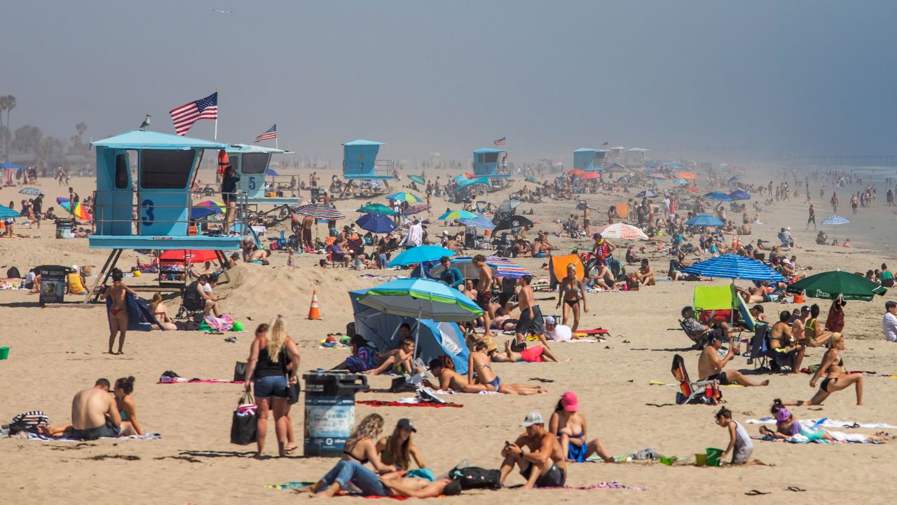 People enjoy the beach amid the novel coronavirus pandemic in Huntington Beach, California on April 25, 2020.