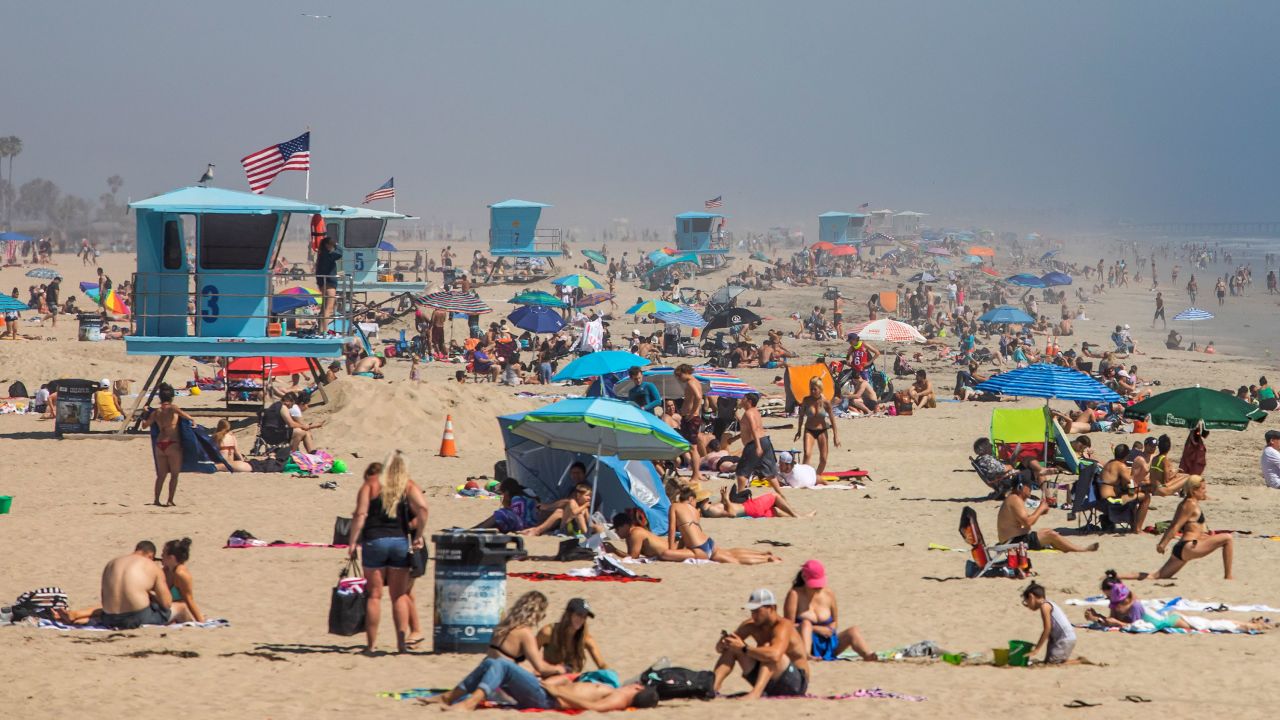 People enjoy the beach amid the novel coronavirus pandemic in Huntington Beach, California on April 25, 2020.
