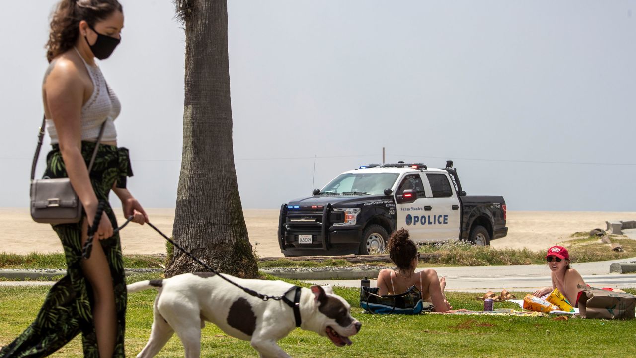Santa Monica police keep watch over the empty beach and closed bike path as law enforcement presence was heavy along the coast to keep people off of closed Los Angeles County beaches on Saturday, April 25, 2020.