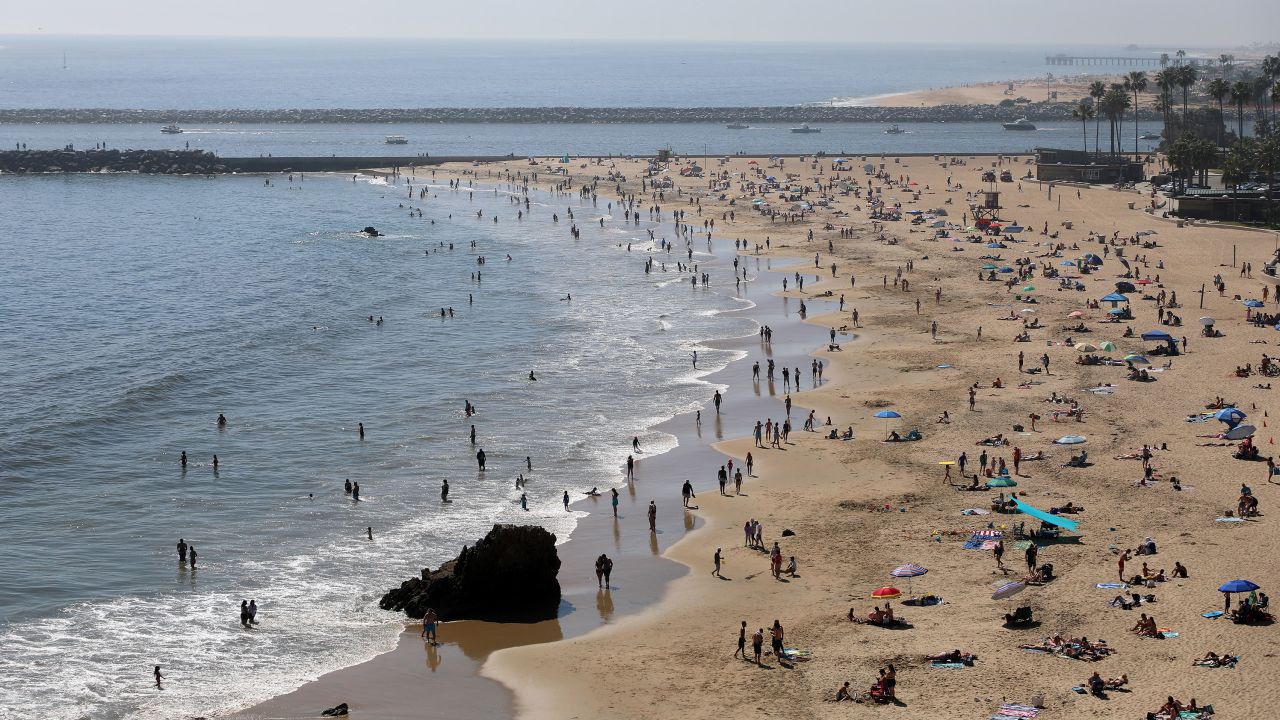 People are seen gathering on the Corona del Mar State Beach on April 25, 2020 in Newport Beach, California.