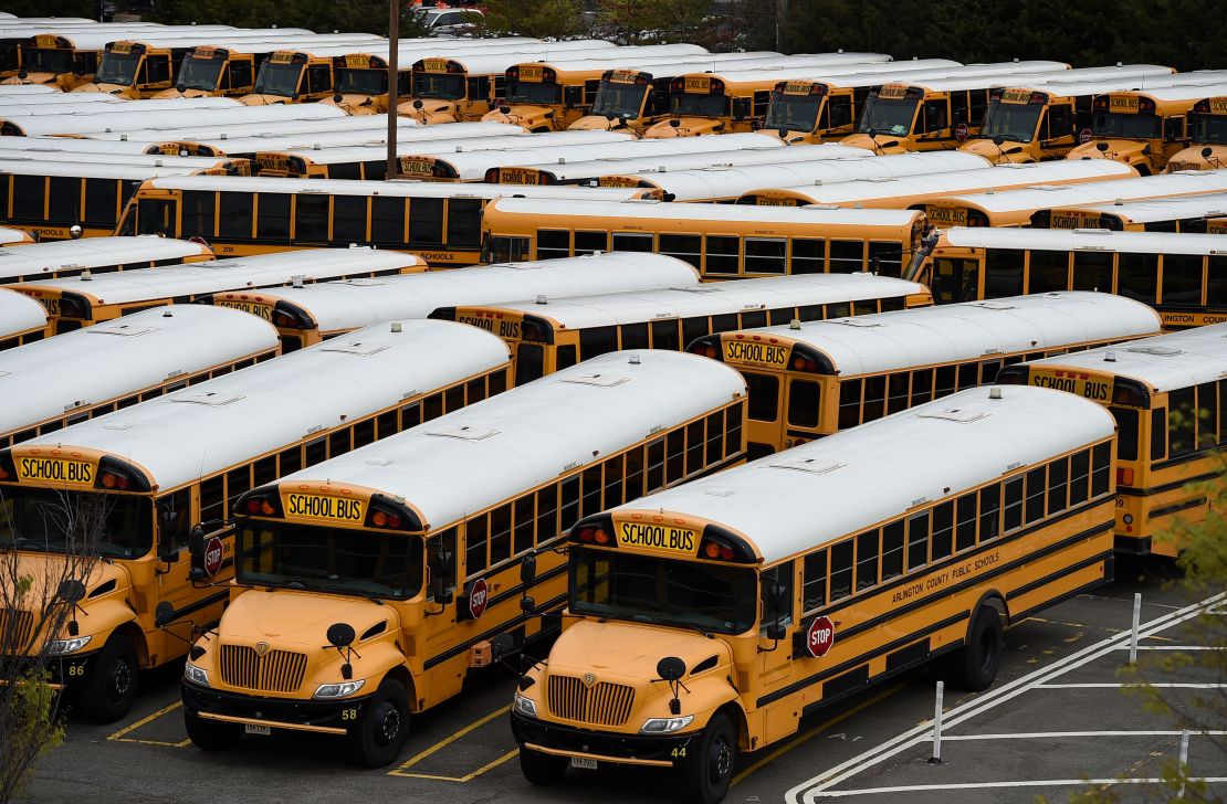School buses sit parked at the Arlington County Bus Depot, in Virginia. Administrators have to consider how children get to school as well as their time inside.