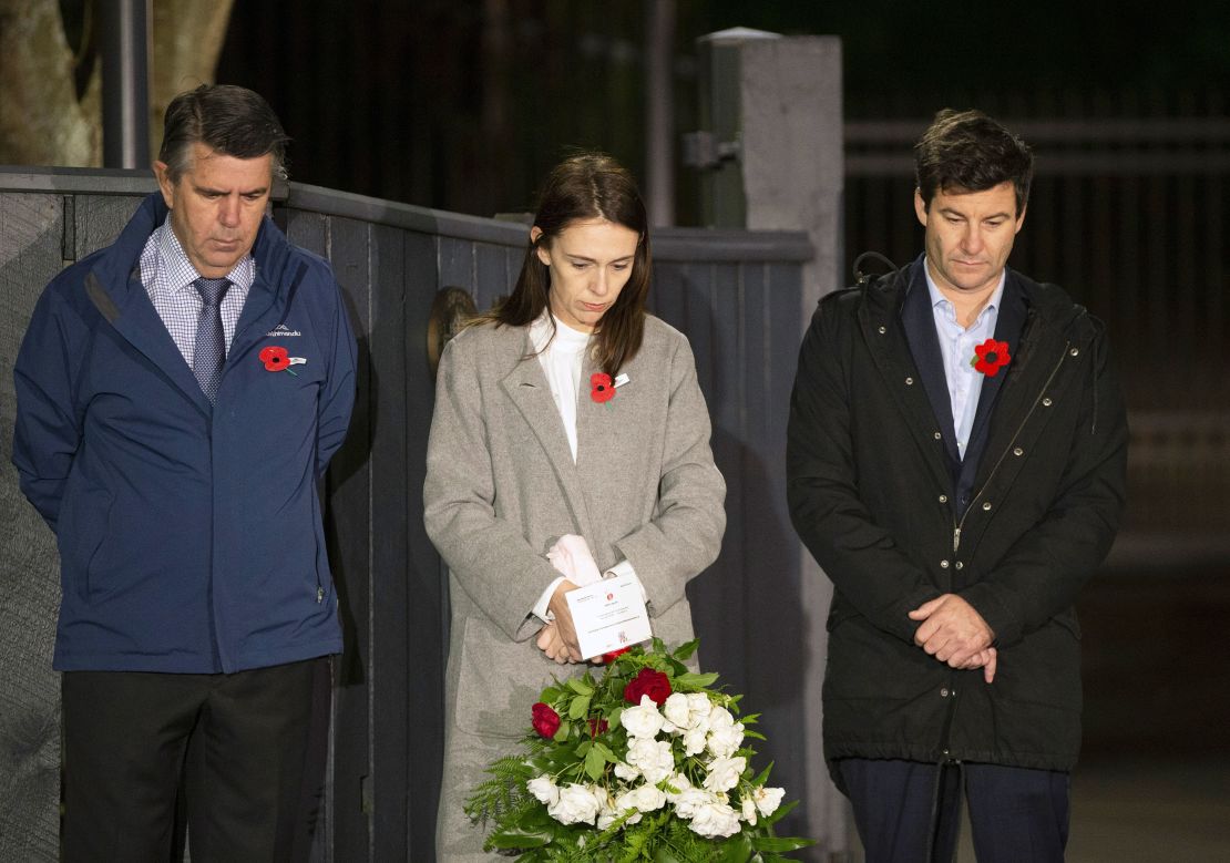 New Zealand Prime Minister Jacinda Ardern stands at dawn on the driveway of Premier House with her father Ross Ardern, left, and partner Clarke Gayford to commemorate Anzac Day in Wellington, New Zealand, on April 25, 2020.