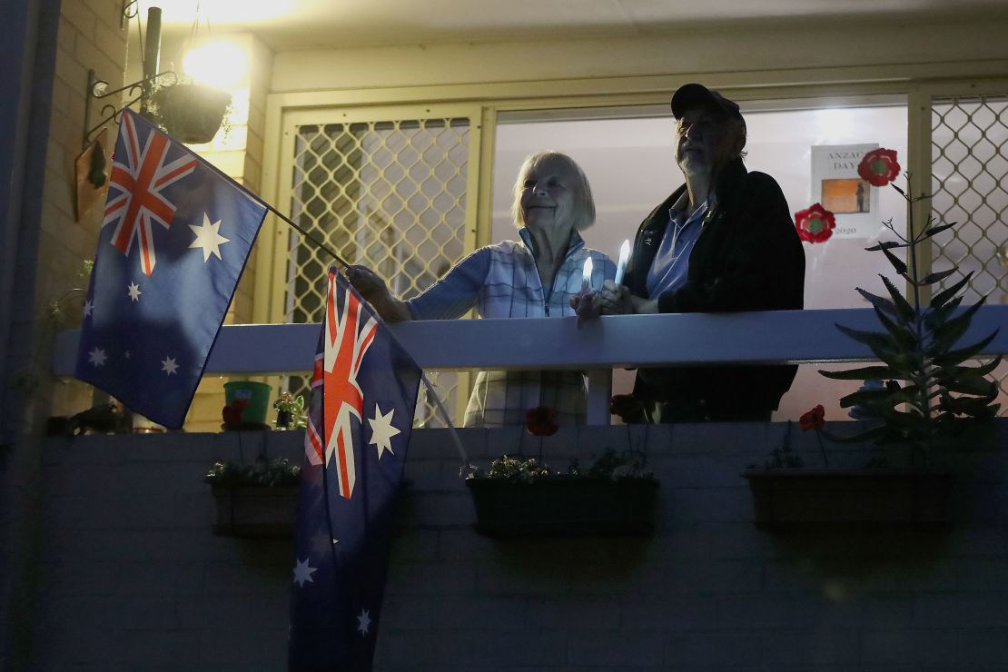 Doreen and Leith Ward pay their respects at dawn from their balcony on April 25, 2020 in Perth, Australia.