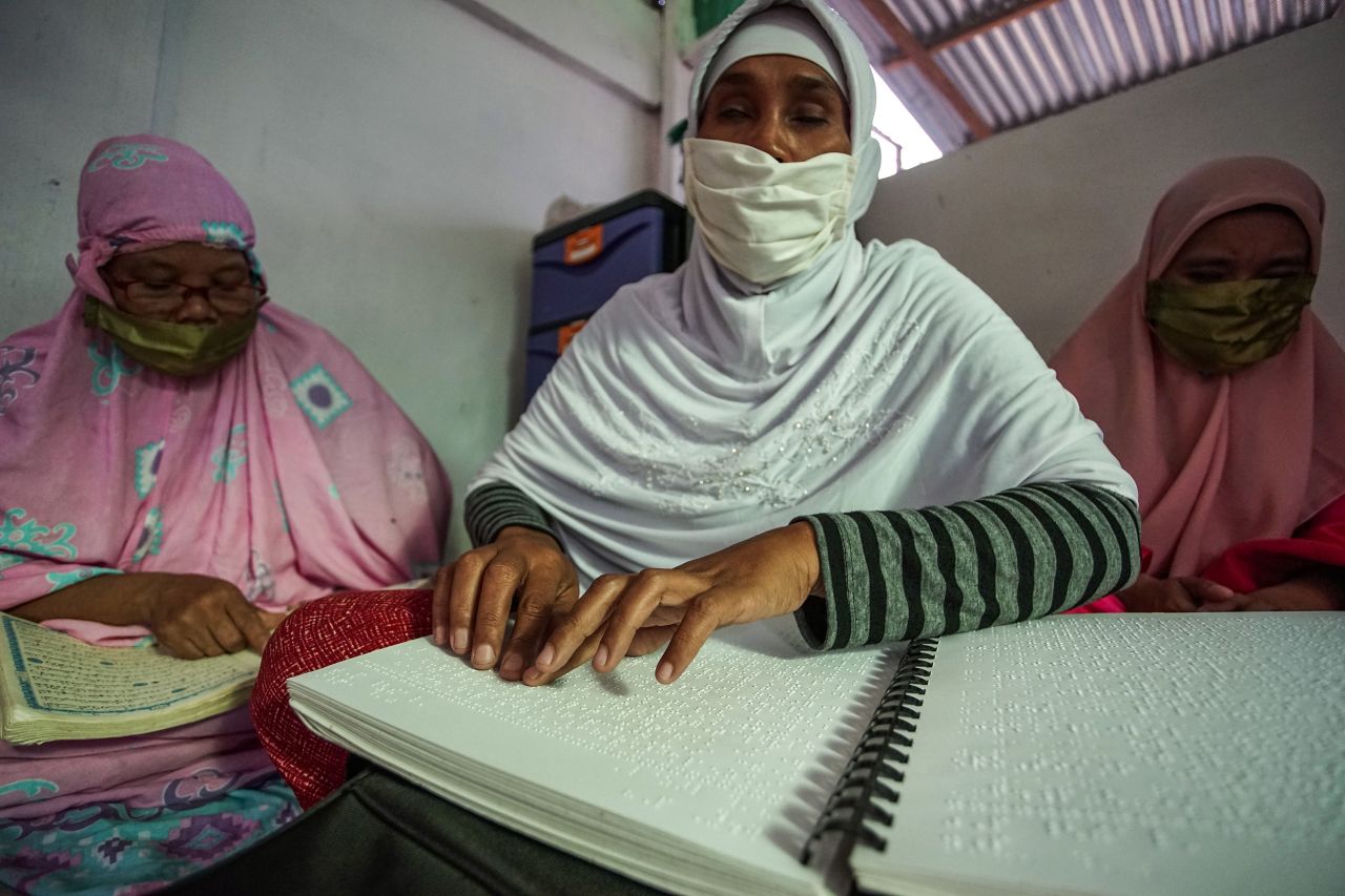 A blind woman in Medan, Indonesia, reads the Quran on April 26. 