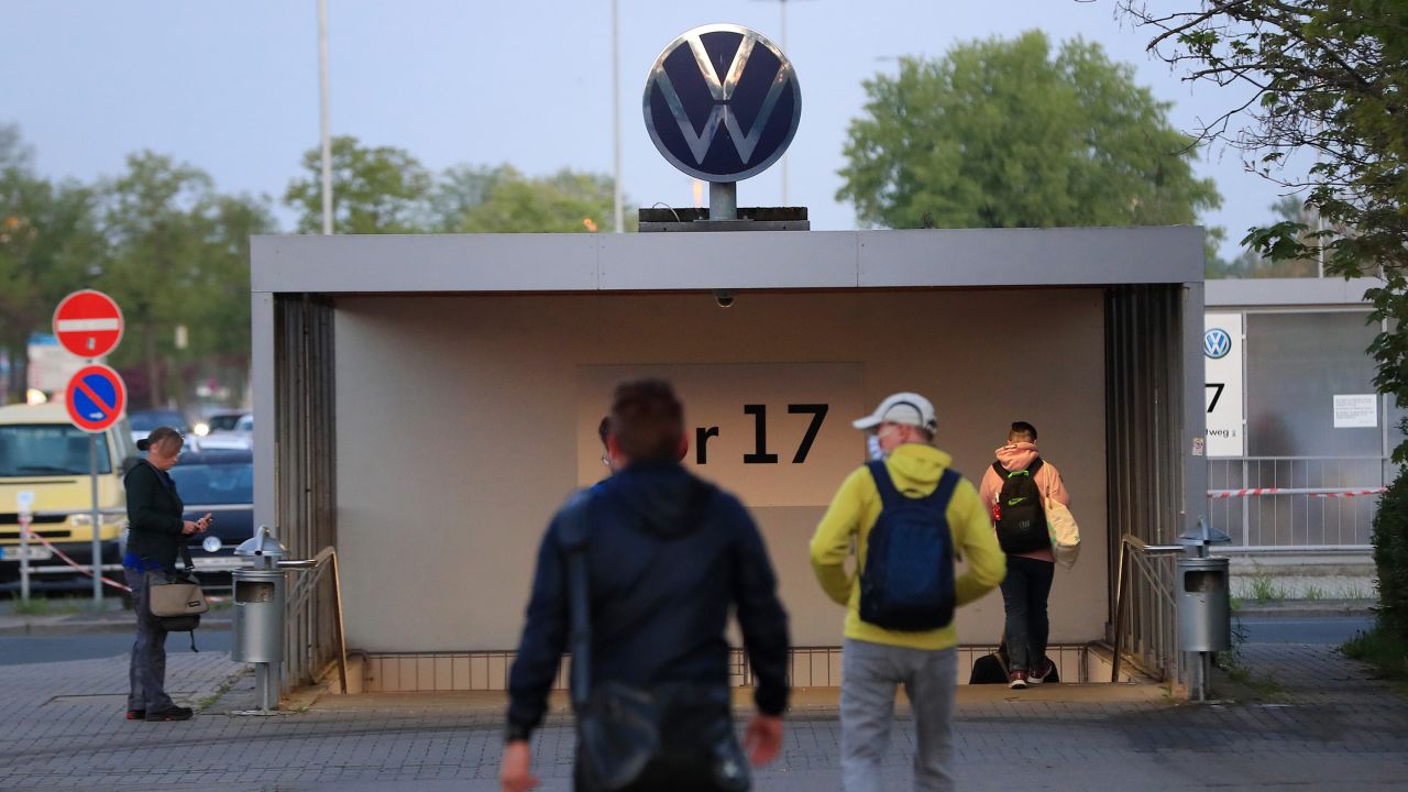Employees walk towards an entrance gate at the Volkswagen plant in Wolfsburg, Germany, on April 27, 2020. 