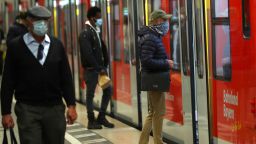 People wearing face masks to protect against the spread of the coronavirus at the central station in Munich, Germany, Monday, April 27, 2020. From today face masks are mandatory in Germany when shopping and at public transport due to the coronavirus outbreak. (AP Photo/Matthias Schrader)