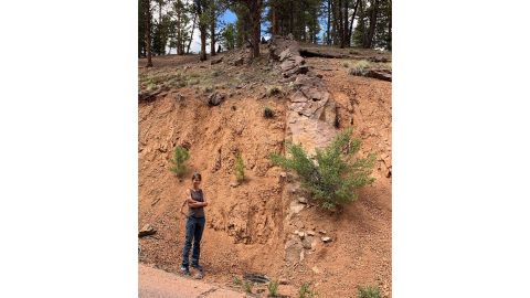 Researcher Rebecca Flowers stands near a rock outcrop on Pikes Peak in Colorado.