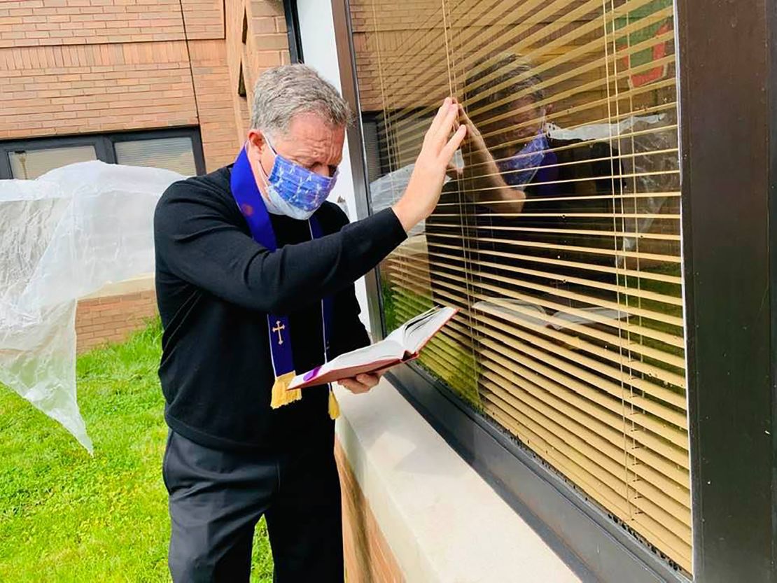 An Episcopal priest gives last rites through a nursing home window to a parishioner dying of coronavirus.